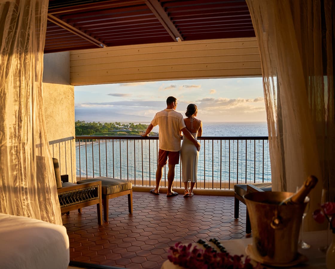 A couple viewing the ocean from their balcony